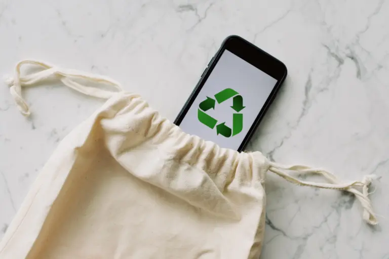 Tote bag made from eco-friendly materials, phone screen shows recycling icon. Go green