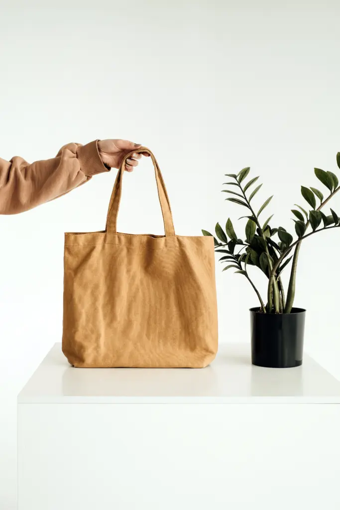 Eco-friendly tote bag on a counter next to potted plants.