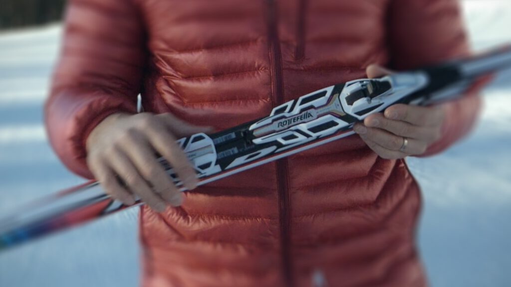 Expert instructor proudly displaying a ski equipped with Rottefella binding, highlighting its advanced features and design.