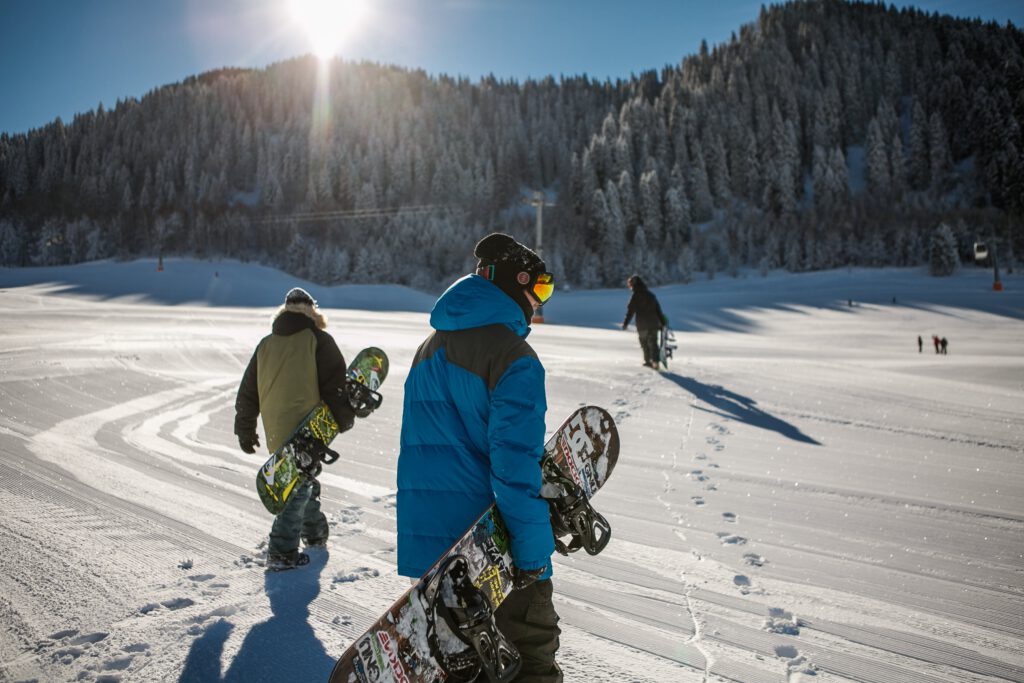 A group of snowboarder on the slopes wearing a warm cozy jacket over a mid-layer ski jacket.